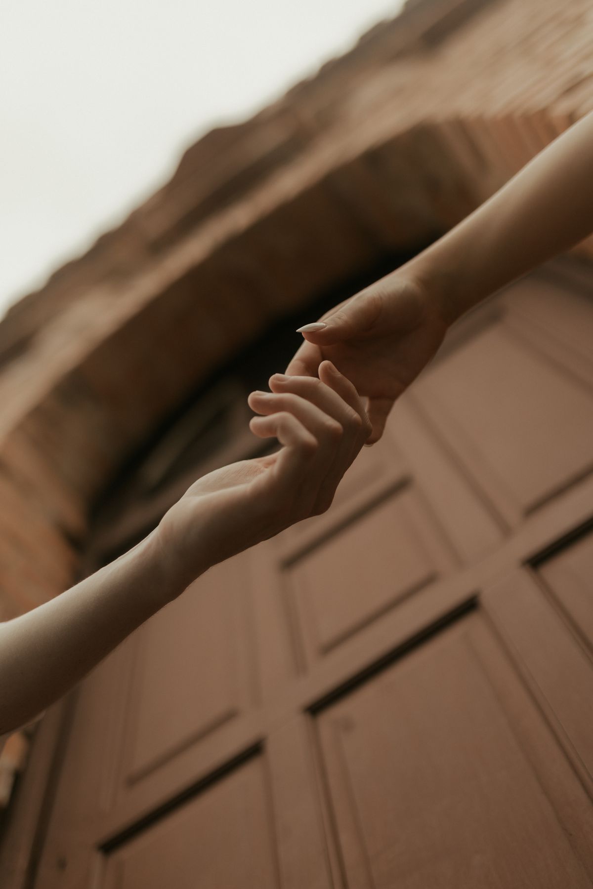 Two hands reaching for each other in warm light